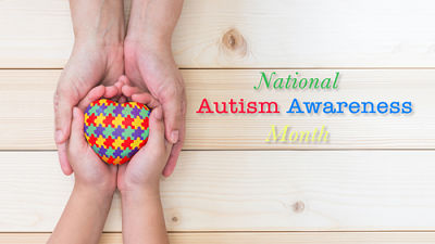 A set of adult hands holding a set of child\'s hands holding on to a multicolored heart. National Autism Awareness Month
