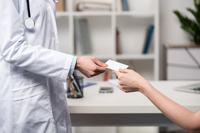 A medical professional handing a business card to a patient