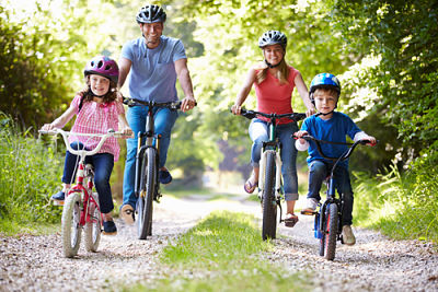 A family riding their bikes down a gravel trail