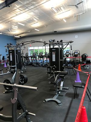 Photo of a weight room containing exercise machines and free weights